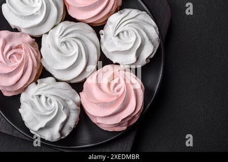 Köstliches süßes mehrfarbiges Marshmallow auf dunklem Betonhintergrund Stockfoto