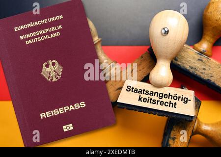 FOTOMONTAGE, Stempel mit Aufschrift Staatsangehörigkeitsrecht auf deutscher Fahne und deutscher Pass, Gesetz zur Modernisierung des Staatsangehörigkeitsrechts *** FOTOMONTAGE, Stempel mit Aufschrift Staatsangehörigkeitsrecht auf deutscher Flagge und deutscher Pass, Gesetz zur Modernisierung des Staatsangehörigkeitsrechts Stockfoto