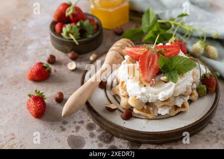 Belgische Waffeln mit frischen Berrie-Erdbeeren und Ricotta-Käse zum Frühstück auf Steinboden. Stockfoto