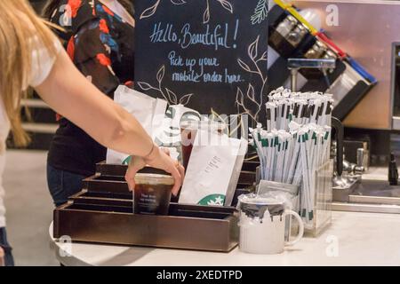 NEW YORK, USA - 15. MAI 2019: Schalter im Starbucks Café mit Strohhalmen und Getränken zum Mitnehmen Stockfoto