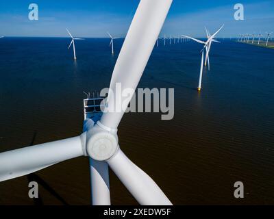 Windkraftanlagen erzeugen Energie aus dem Wind inmitten eines riesigen Gewässers in den Niederlanden Stockfoto