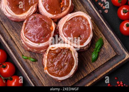 Köstliche rohe, frische Schweinefleisch- oder Hühnchenfleisch-Brötchen, in Speck gewickelt Stockfoto