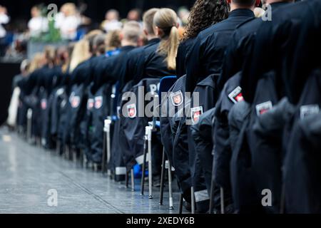 Hannover, Deutschland. Juni 2024. Angehende Polizisten des Bachelorstudiengangs der Polizeiakademie Niedersachsen nehmen an ihrer Vereidigung in der Swiss Life Hall Teil. Rund 1000 potenzielle Polizeikommissare legten in Hannover ihren Amtseid auf das Grundgesetz und die Verfassung Niedersachsens ab. Quelle: Michael Matthey/dpa/Alamy Live News Stockfoto