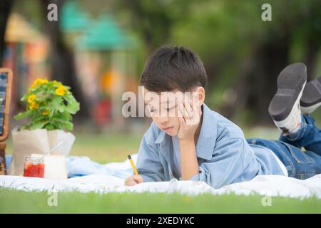 Glückliche Familie, die ein Picknick im Park genießt, mit Kindern, die Spaß im Sitzen haben, umgeben von der Natur Stockfoto