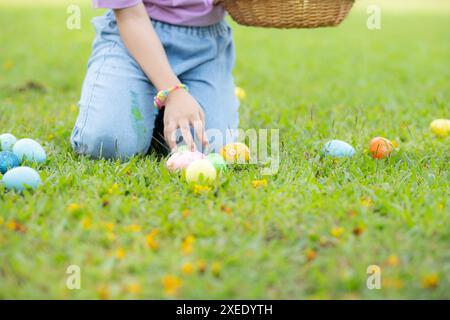 Kinder genießen Outdoor-Aktivitäten im Park, einschließlich eines Laufs, um wunderschöne Ostereier zu sammeln. Stockfoto