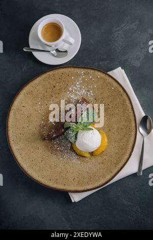 Schokoladenbrownie mit Eis und Vanillepulver auf Teller Stockfoto