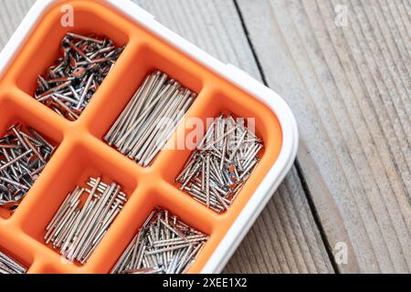 Sammlung von Nägeln, Schrauben und Bolzen in Kunststoffkiste Stockfoto