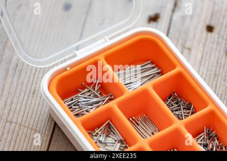 Sammlung von Nägeln, Schrauben und Bolzen in Kunststoffkiste Stockfoto