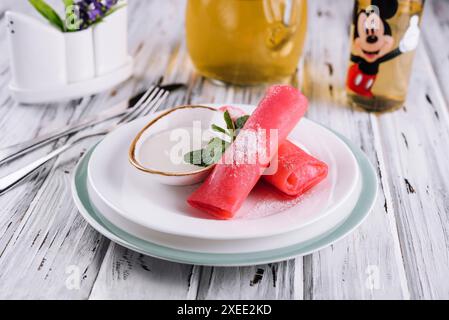 Gerollte Himbeerpfannkuchen mit Sauerrahm für Kinder Stockfoto