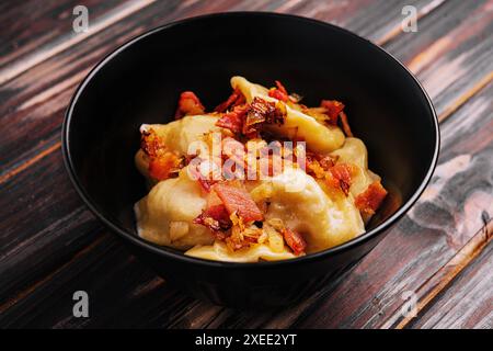 Gebackene Kartoffelknödel mit gebratenem Speck und Zwiebeln Stockfoto