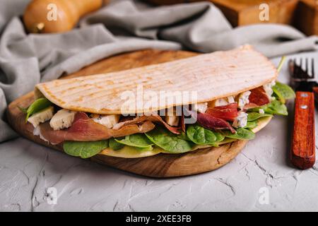 Piadina: Klassisches italienisches Tortilla-Brot mit Schinken, Basilikum und Dor Blue Stockfoto