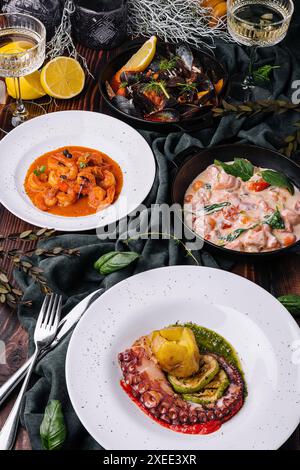 Oktopus Sizilianer, Lachs in Sahnesauce, Garnelen in Romesco-Sauce und Muscheln Stockfoto