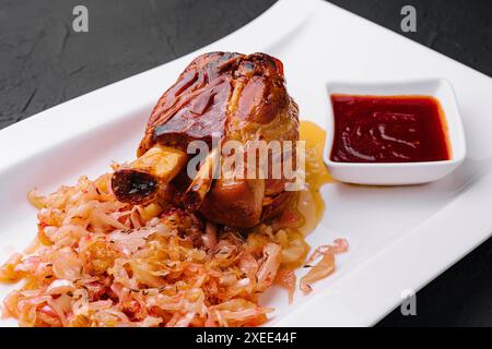 Bayerische Schweinshaxe mit Sauerkraut auf Teller Stockfoto