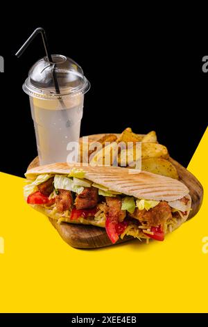 Leckerer Hühnchendöner mit gebratener Kartoffel auf einem Holztisch Stockfoto