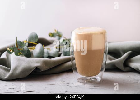 Hitzebeständiger doppelwandiger Glasbecher gefüllt mit Latte oder Cappuccino Stockfoto