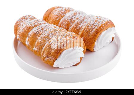 Gebackene Röhrchen mit Schlagsahne auf Teller Stockfoto