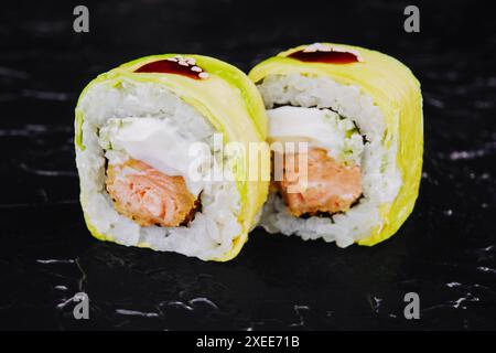 In Avocado gewickelte Brötchen mit gebratenem Lachs Stockfoto