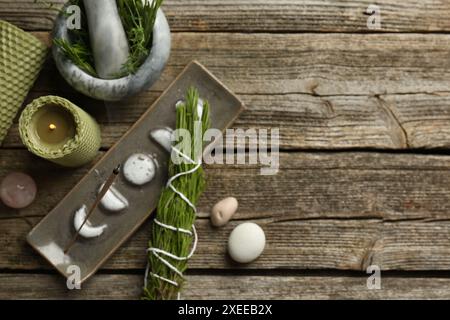 Flache Lagenkomposition mit Räucherstäbchen schwelend in Halter auf Holztisch, Platz für Text Stockfoto