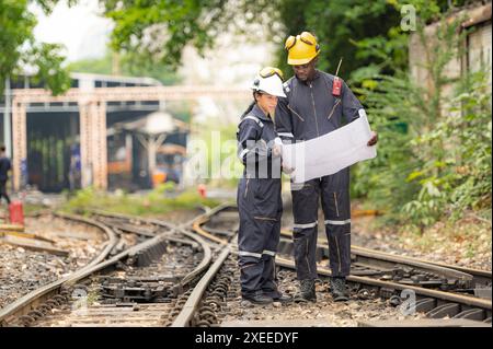 Eisenbahntechniker und -Ingenieure, die auf den Gleisen am Bahnhof arbeiten Stockfoto