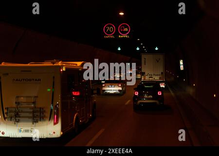 Menton, Frankreich - 12. Mai 2023: Eine Reihe von Autos fährt nachts durch einen Tunnel. Die Geschwindigkeitsbegrenzung beträgt 70 km/h, und es gibt ein Schild, das große Fahrzeuge einschränkt Stockfoto