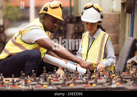 Eisenbahntechniker in Sicherheitsweste und Helm überprüfen die Batterie in der Zugwerkstatt. Stockfoto