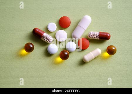 Pillen, Vitamine und Nahrungsergänzungsmittel auf grünem Hintergrund. Stockfoto