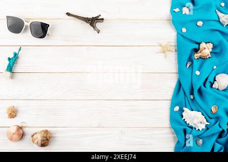 Muscheln, Sonnenbrillen, Kompass-Souvenirs, blauer Stoff und Seesterne auf weißen Planken Urlaubsplanung Stockfoto