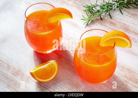 Orangengetränke mit Rosmarin auf hölzernem Hintergrund, frisch gepresster Saft Stockfoto