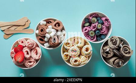 Gerolltes Eis in Kegelbecher auf blauem Hintergrund Stockfoto