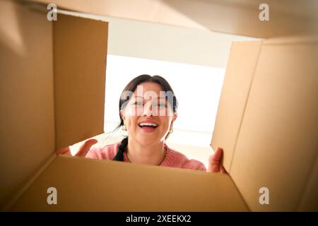Sehen Sie Sich Die Junge Aufgeregte Frau An, Die Den Karton Öffnet Stockfoto