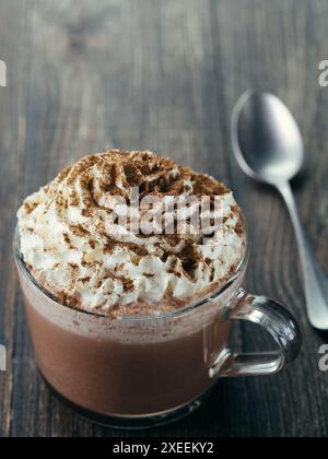 Glas Becher mit heißer Schokolade und Sahne Stockfoto