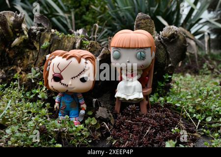 Funko Pop Actionfiguren von bösen Puppen aus Horrorfilmen. Chucky aus dem Kinderspiel und Annabelle aus der Beschwörung. Düsterer dunkler Wald. Stockfoto