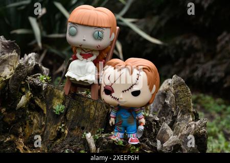 Funko Pop Actionfiguren von bösen Puppen aus Horrorfilmen. Chucky aus dem Kinderspiel und Annabelle aus der Beschwörung. Düsterer dunkler Wald. Stockfoto