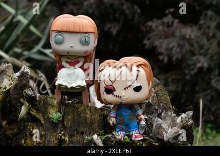 Funko Pop Actionfiguren von bösen Puppen aus Horrorfilmen. Chucky aus dem Kinderspiel und Annabelle aus der Beschwörung. Düsterer dunkler Wald. Stockfoto