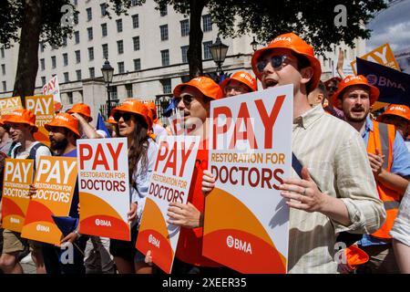 London, Großbritannien 27 Juni 2024 Junior Doctors demonstrieren gegenüber der Downing Street. Juniorärzte in England werden heute zum elften Mal über die Bezahlung streiken, da sie befürchten, dass ein Stillstand so kurz vor den Parlamentswahlen ein „eigenes Ziel“ ist. Rund 25.000 Ärzte werden während der fünftägigen Unterbrechung, die heute um 7 Uhr morgens beginnt und bis zur gleichen Zeit am nächsten Dienstag, den 2. Juli, läuft, voraussichtlich nicht arbeiten. Bis zum Ende werden Ärzte in der Ausbildung 44 Tage lang streiken, seit sie im März 2023 erstmals Arbeitskampfmaßnahmen ergriffen haben, um eine Gehaltserhöhung von 35 % zu erreichen. Stockfoto