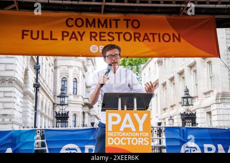 London, UK 27 Juni 2024 DR ROBERT LAURENSON, Ko-Vorsitzender des Junior Doctors Committee. Junior Doctors demonstrieren gegenüber der Downing Street. Juniorärzte in England werden heute zum elften Mal über die Bezahlung streiken, da sie in ihrer gewerkschaft besorgt sind, dass ein Stillstand so kurz vor den Parlamentswahlen ein "eigenes Ziel" ist. Rund 25.000 Ärzte werden während der fünftägigen Unterbrechung, die heute um 7 Uhr morgens beginnt und bis zur gleichen Zeit am nächsten Dienstag, den 2. Juli, läuft, voraussichtlich nicht arbeiten. Bis zum Ende werden Ärzte in der Ausbildung seit 44 Tagen im Streik sein, seit sie im März 2023 erstmals Arbeitskampfmaßnahmen ergriffen haben Stockfoto