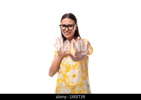 Junge lächelnde brünette Frau mit Brille, die ein sommeroranges T-Shirt trägt Stockfoto