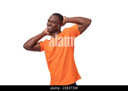 Junger netter amerikanischer Mann in einem orangen T-Shirt auf weißem Hintergrund mit Kopierraum Stockfoto