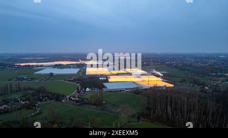 Duffel, Belgien, 20. März 2024, Twilight over Techno-Agriculture: Leuchtende Gewächshäuser in der Abenddämmerung Stockfoto