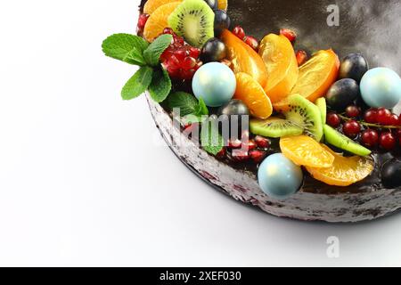 KIEW, UKRAINE Schokoladenkuchen, dekoriert mit Heidelbeeren, Keksen und Seifenblasen-Schokolade auf schwarzem Hintergrund. Brauner Frischkäse Stockfoto