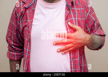 Imitative Darstellung des Altersherzschmerzes. Ein alter Mann mit Brustbeschwerden oder Herzinfarkt. Stockfoto