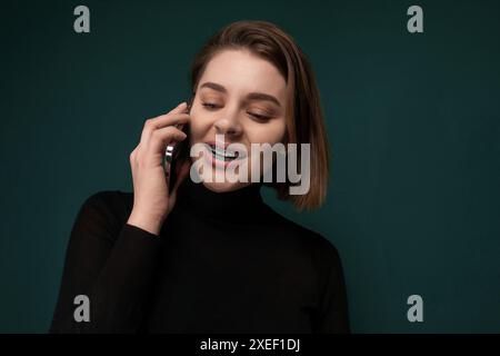 Frau, die mit einem Lächeln auf dem Handy spricht Stockfoto