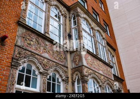 Fassade eines alten Vintage-Hauses im deutschen Stil. Reich verzierte Fassade eines antiken Gebäudes. Die Fenster und Wände sind mit Stuck verziert und bemalt Stockfoto