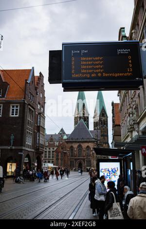 Bremen, Deutschland - 11.03.2023: Straße einer Großstadt, eine alte Kathedrale im gotischen Stil, eine Straßenbahnhaltestelle, Passagiere steigen aus und steigen in den Verkehr Stockfoto