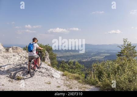 Freizeitradfahrer mit einem E-Mountainbike auf weißem Schotterweg. EMTB-Fahrradkonzept. Stockfoto
