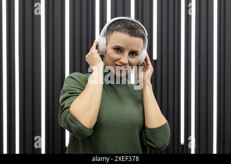 Erfolgreiche Finanzierin hört während einer Pause Musik und entspannt sich Stockfoto