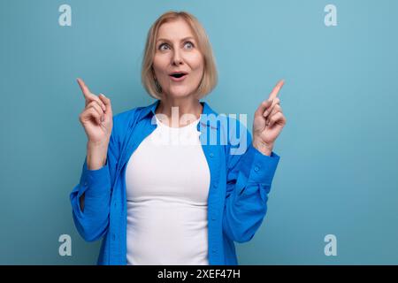 Verträumte blonde reife Frau mit bob-Haarschnitt auf Studiohintergrund Stockfoto