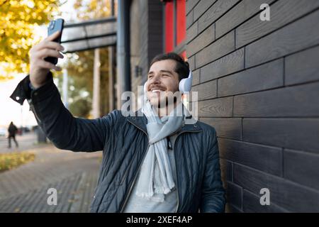 Europäischer Freelancer, der im Freien Selfie mit Kopfhörern macht Stockfoto