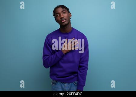 Ruhiger, junger, dunkelhäutiger, brünette Mann mit Dreadlocks in einem blauen Sweatshirt Stockfoto