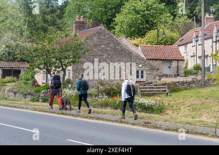 Drei junge Leute spazieren in Helmsley, einer hübschen Stadt im North York Moors National Park, North Yorkshire, England, Großbritannien Stockfoto